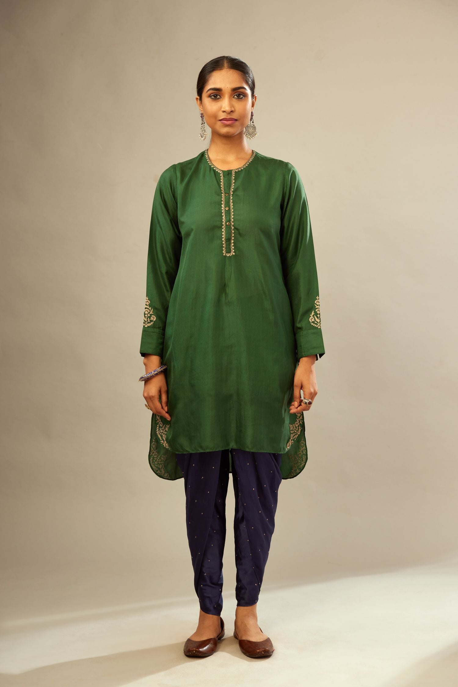Green silk short kurta set with high-low hem with rounded edges, highlighted with gold zari embroidery.