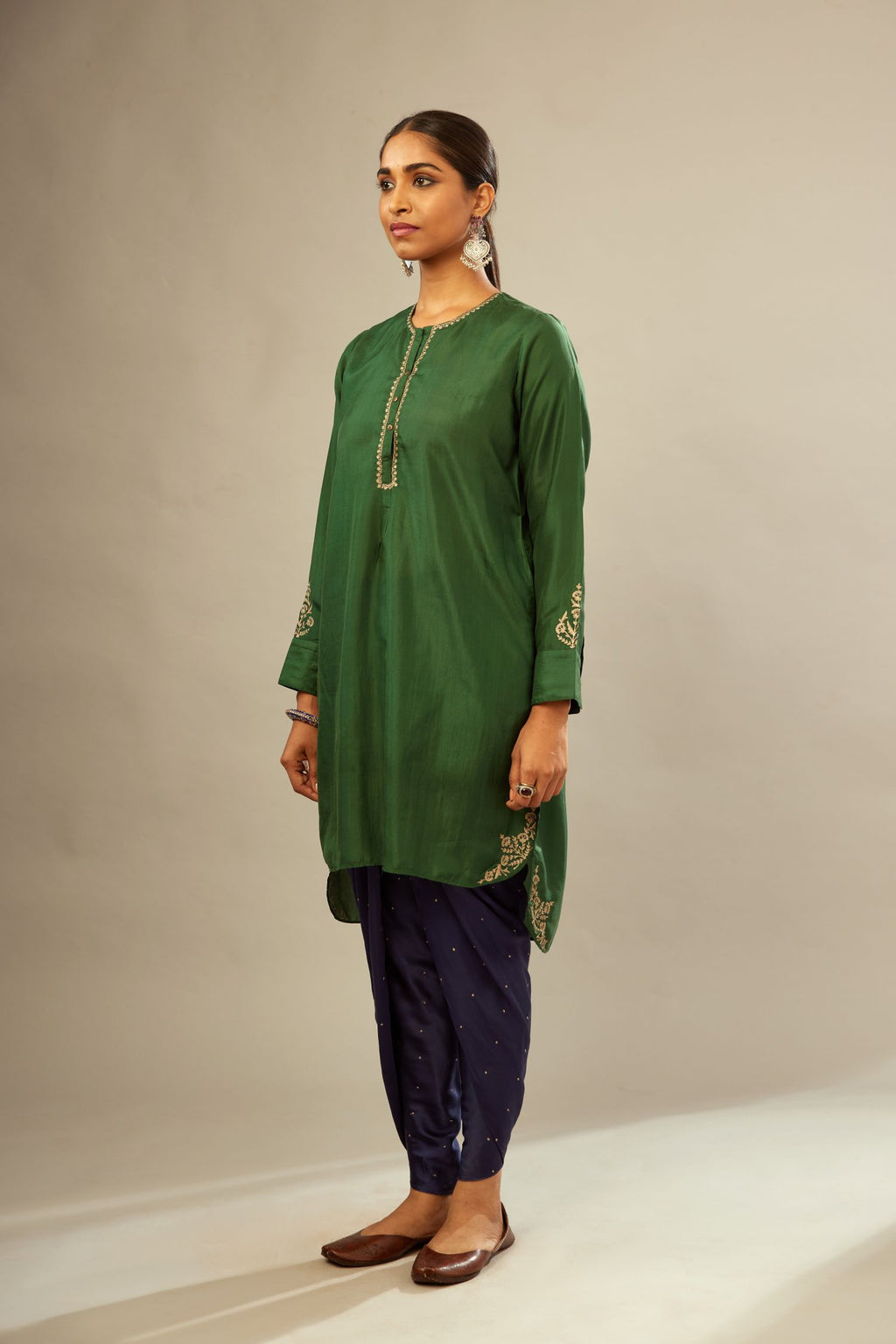 Green silk short kurta set with high-low hem with rounded edges, highlighted with gold zari embroidery.