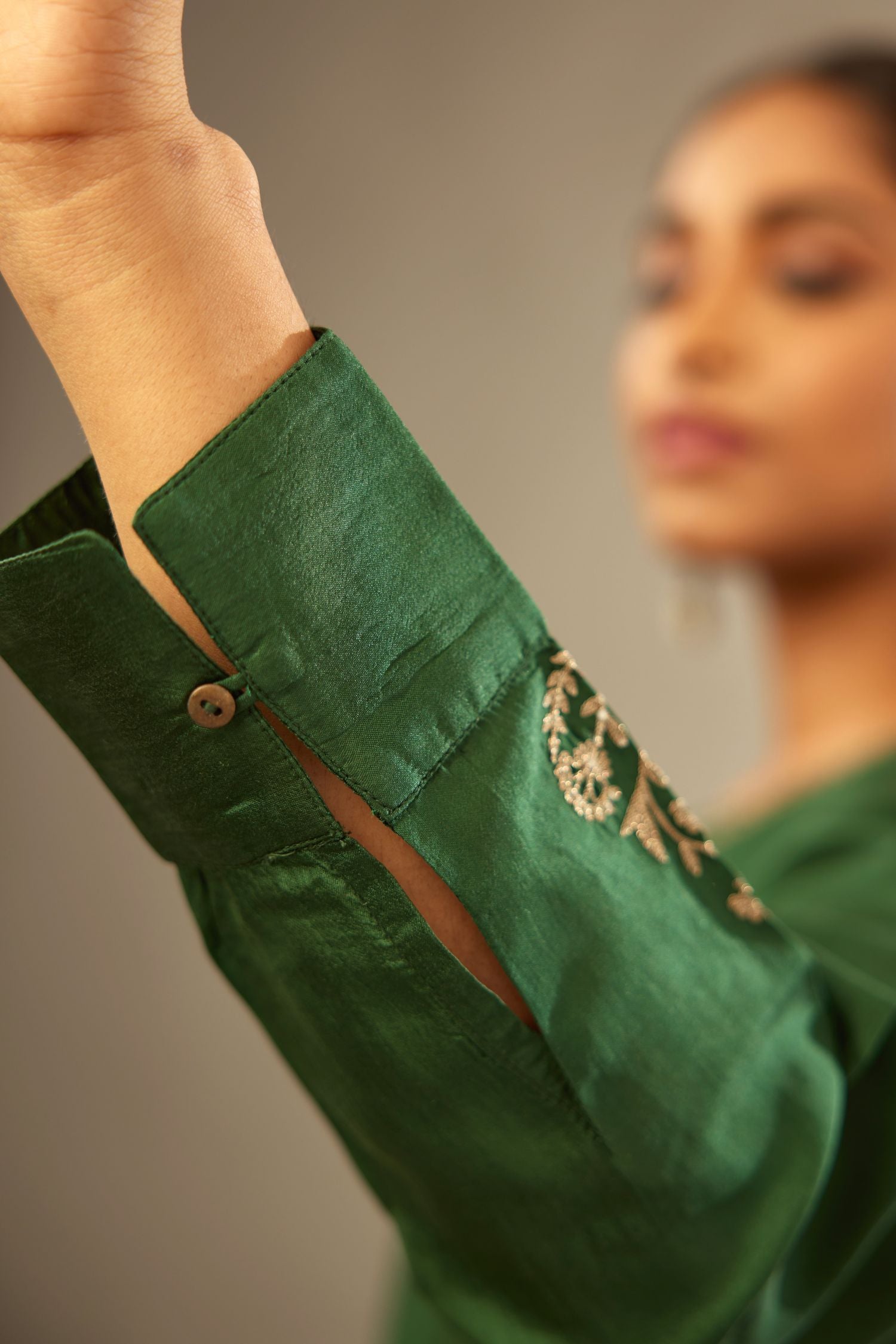 Green silk short kurta set with high-low hem with rounded edges, highlighted with gold zari embroidery.