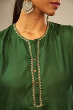 Green silk short kurta set with high-low hem with rounded edges, highlighted with gold zari embroidery.