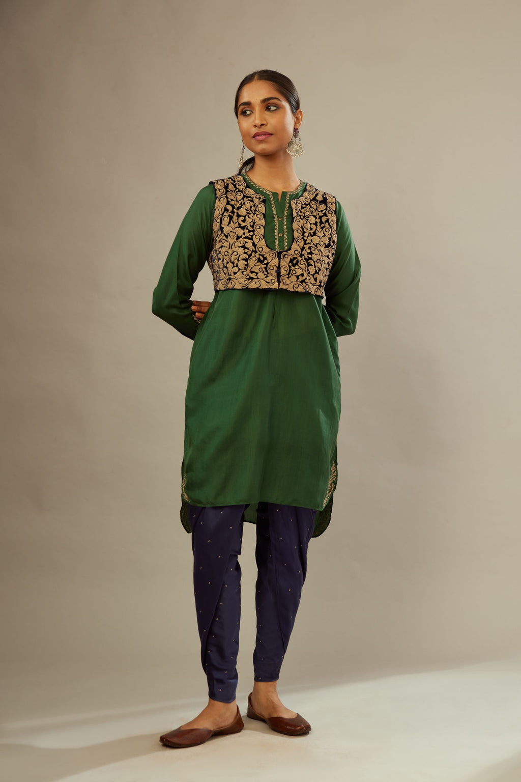 Green silk short kurta set with high-low hem with rounded edges, highlighted with gold zari embroidery.
