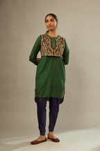 Green silk short kurta set with high-low hem with rounded edges, highlighted with gold zari embroidery.