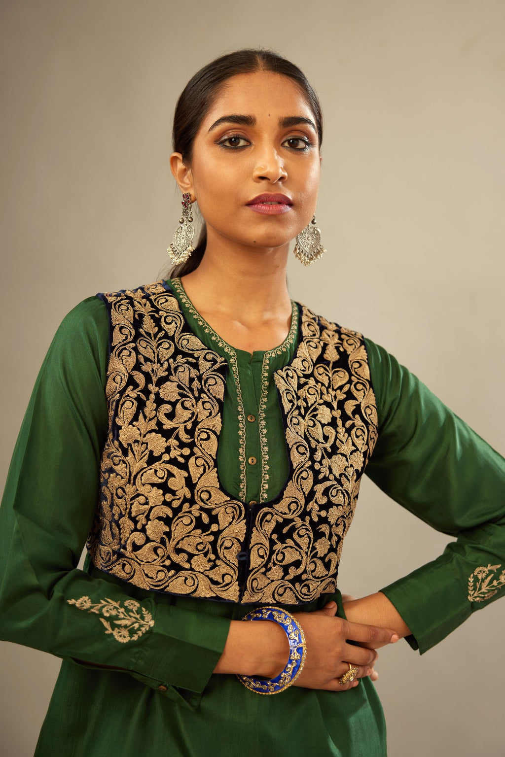 Green silk short kurta set with high-low hem with rounded edges, highlighted with gold zari embroidery.