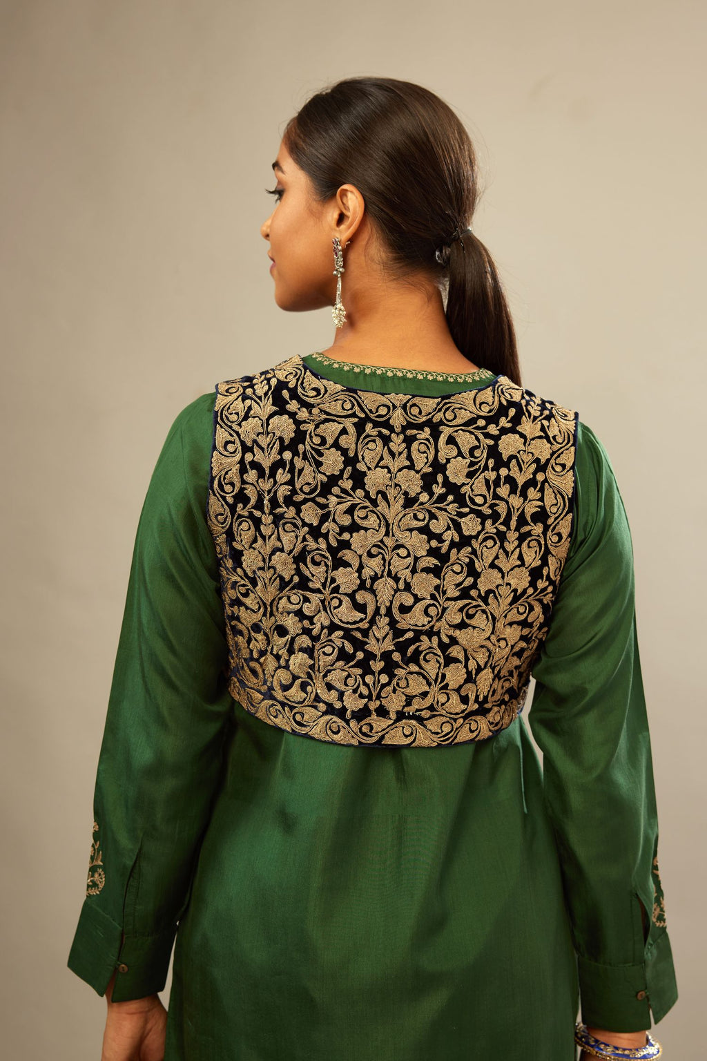 Green silk short kurta set with high-low hem with rounded edges, highlighted with gold zari embroidery.