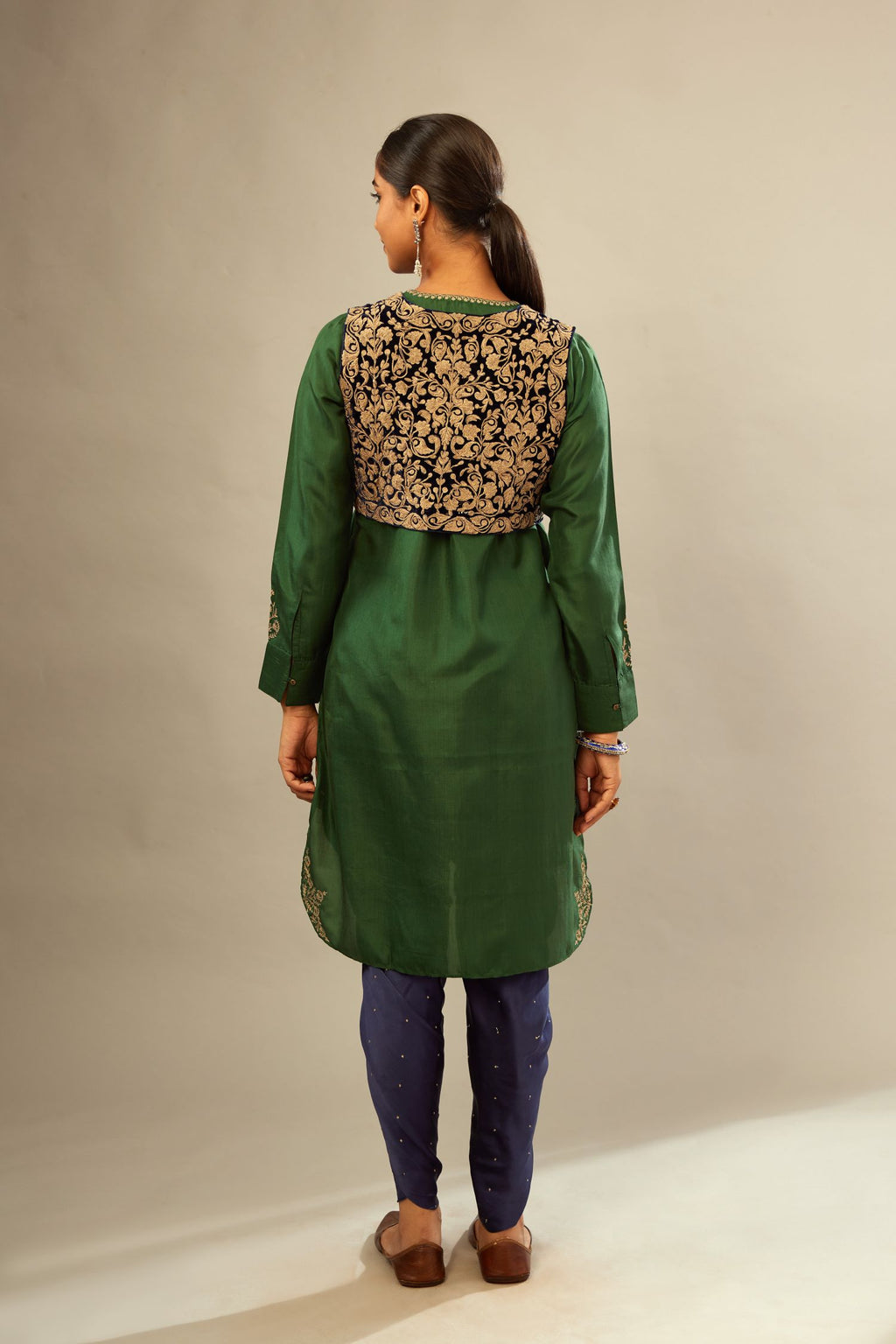 Green silk short kurta set with high-low hem with rounded edges, highlighted with gold zari embroidery.