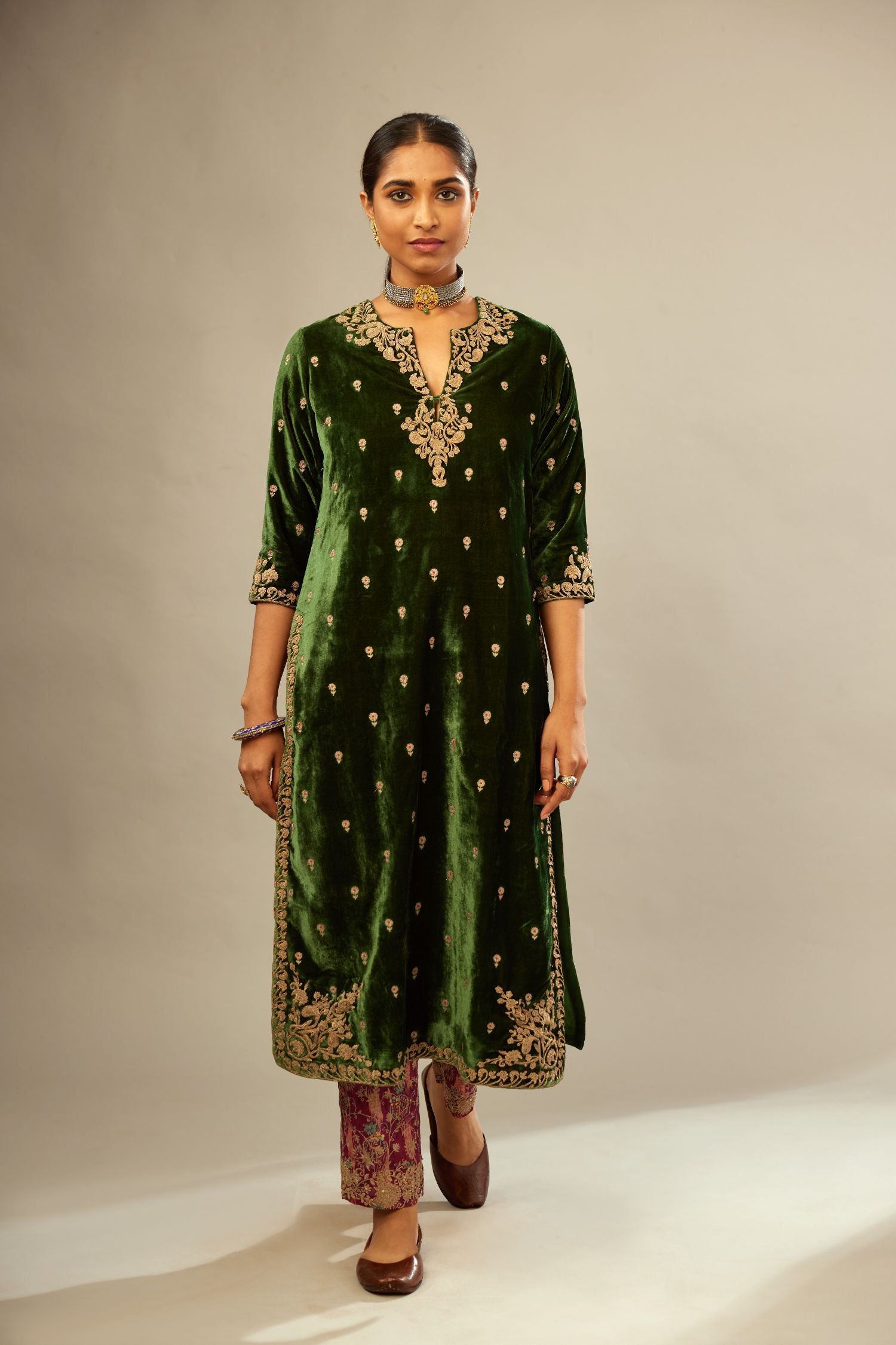 Green silk velvet kurta set with small embroidered zari buties all-over the kurta and detailed with dori embroidery at neck, sleeves, side slits and hem.