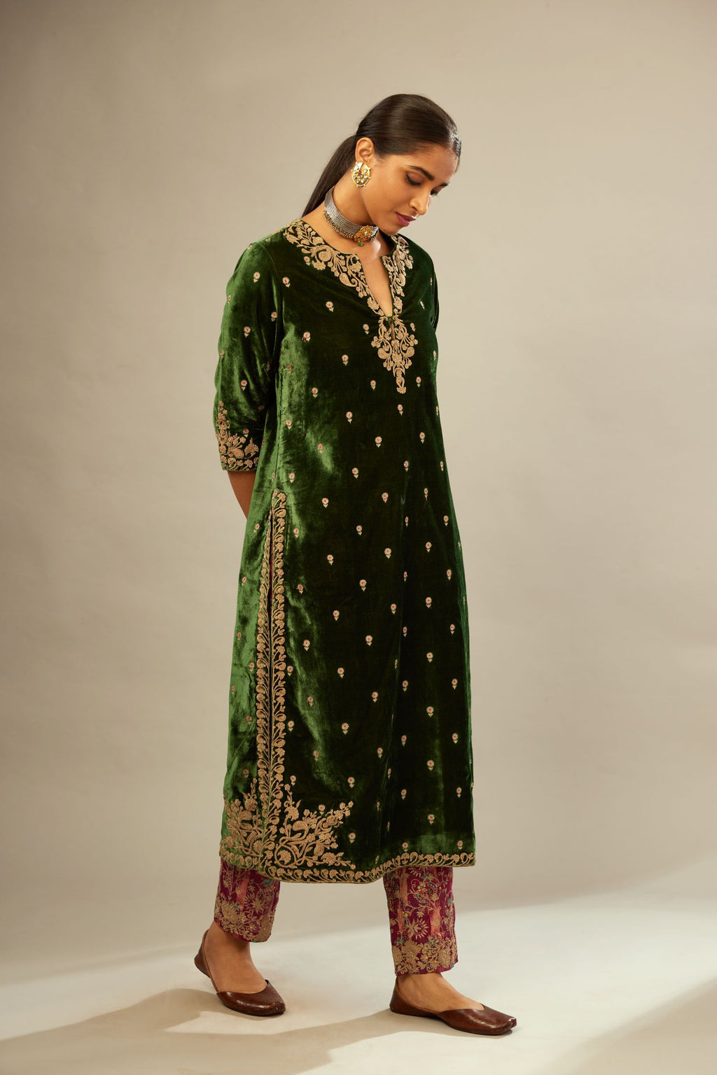 Green silk velvet kurta set with small embroidered zari buties all-over the kurta and detailed with dori embroidery at neck, sleeves, side slits and hem.