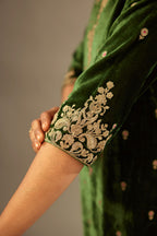 Green silk velvet kurta set with small embroidered zari buties all-over the kurta and detailed with dori embroidery at neck, sleeves, side slits and hem.