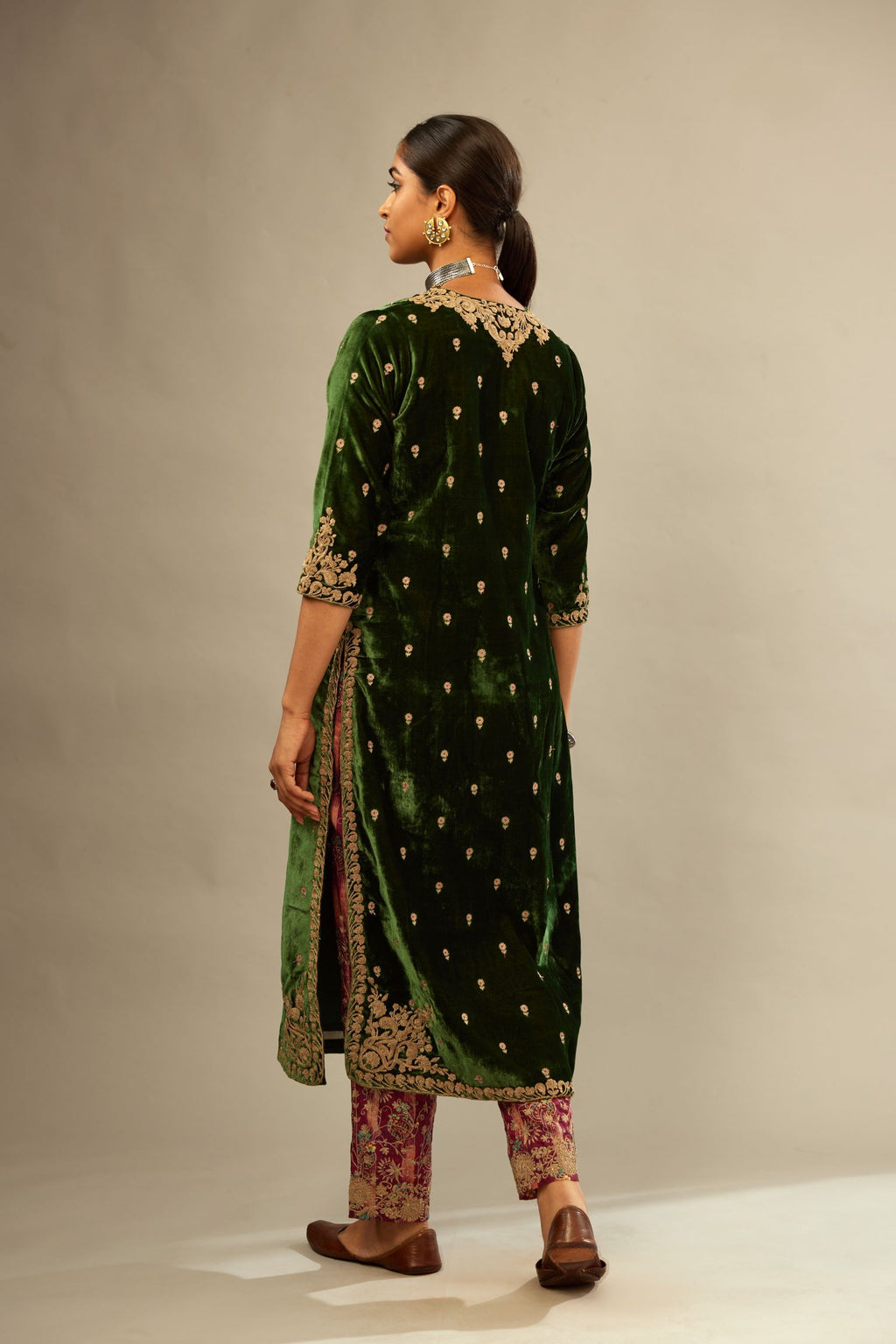 Green silk velvet kurta set with small embroidered zari buties all-over the kurta and detailed with dori embroidery at neck, sleeves, side slits and hem.