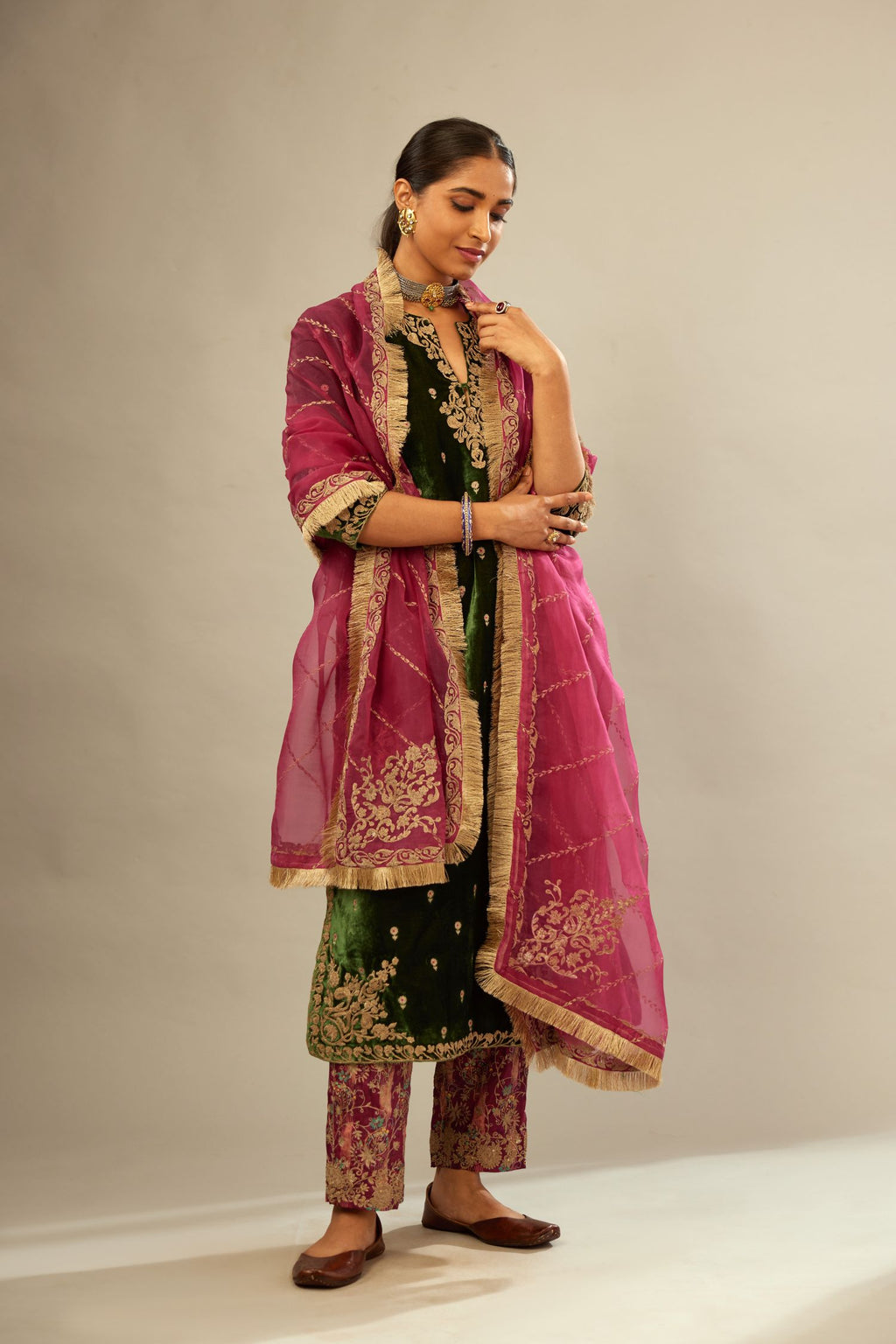 Green silk velvet kurta set with small embroidered zari buties all-over the kurta and detailed with dori embroidery at neck, sleeves, side slits and hem.