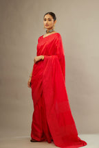 Red silk saree set with a broad border of hand embroidered geometrically aligned sequins and three horizontal bands at the pallu.
