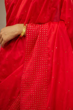 Red silk saree set with a broad border of hand embroidered geometrically aligned sequins and three horizontal bands at the pallu.