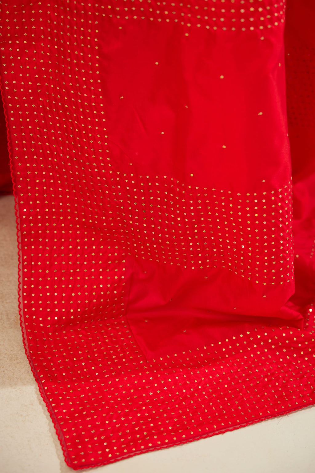 Red silk saree set with a broad border of hand embroidered geometrically aligned sequins and three horizontal bands at the pallu.