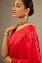 Red silk saree set with a broad border of hand embroidered geometrically aligned sequins and three horizontal bands at the pallu.