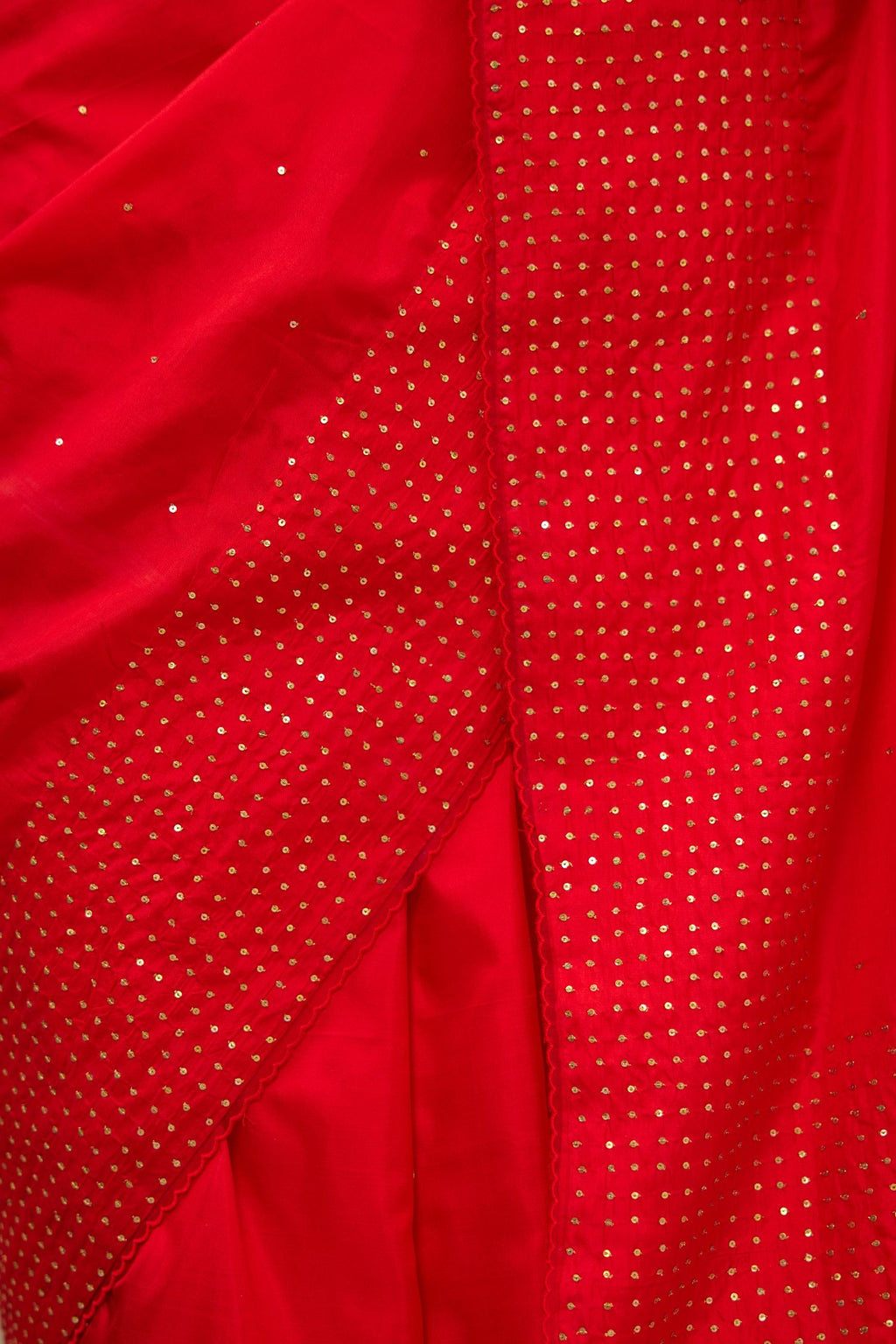 Red silk saree set with a broad border of hand embroidered geometrically aligned sequins and three horizontal bands at the pallu.