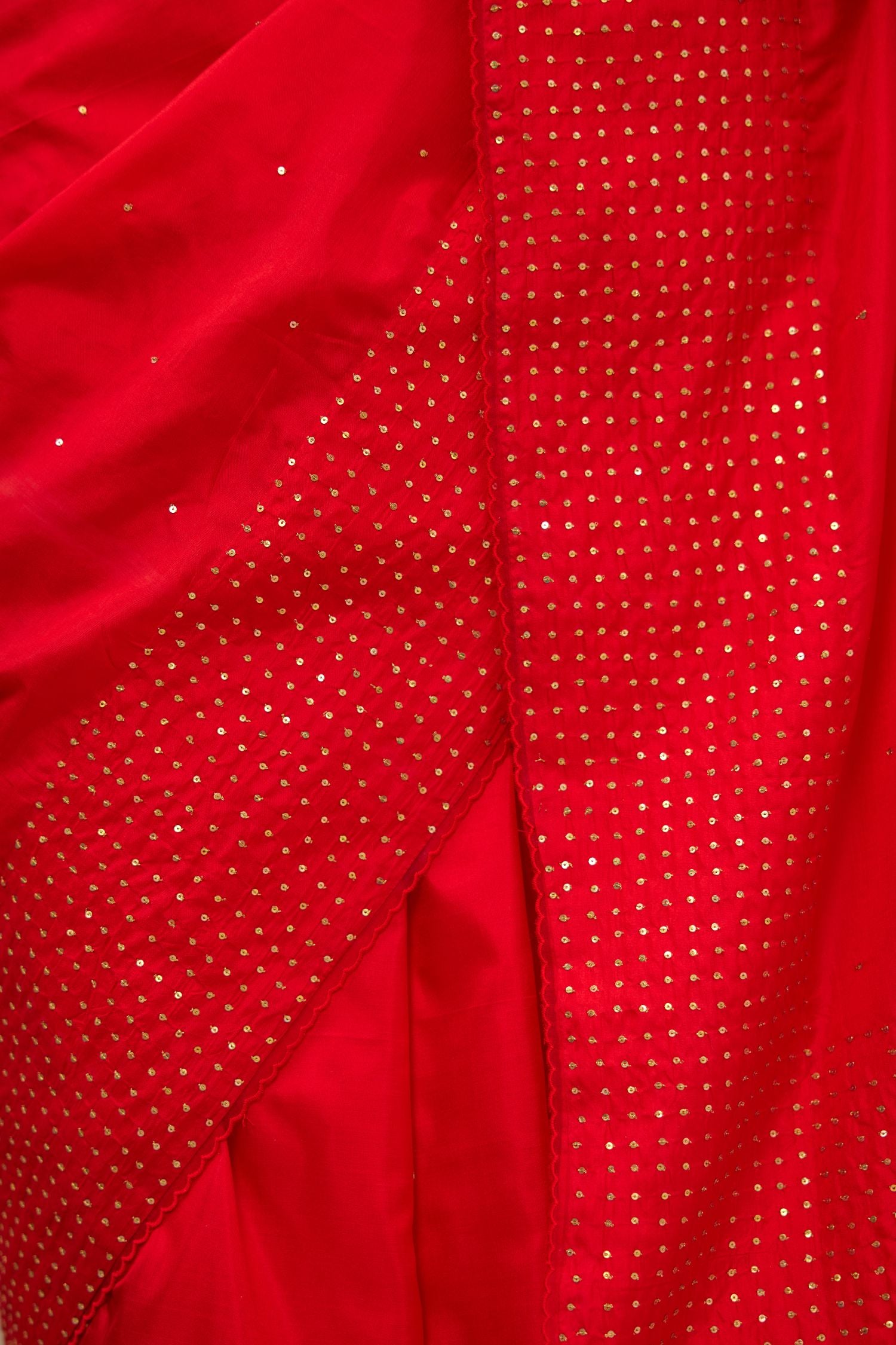 Red silk saree set with a broad border of hand embroidered geometrically aligned sequins and three horizontal bands at the pallu.
