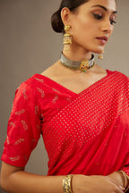 Red silk saree set with a broad border of hand embroidered geometrically aligned sequins and three horizontal bands at the pallu.