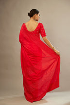 Red silk saree set with a broad border of hand embroidered geometrically aligned sequins and three horizontal bands at the pallu.