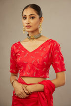 Red silk saree set with a broad border of hand embroidered geometrically aligned sequins and three horizontal bands at the pallu.