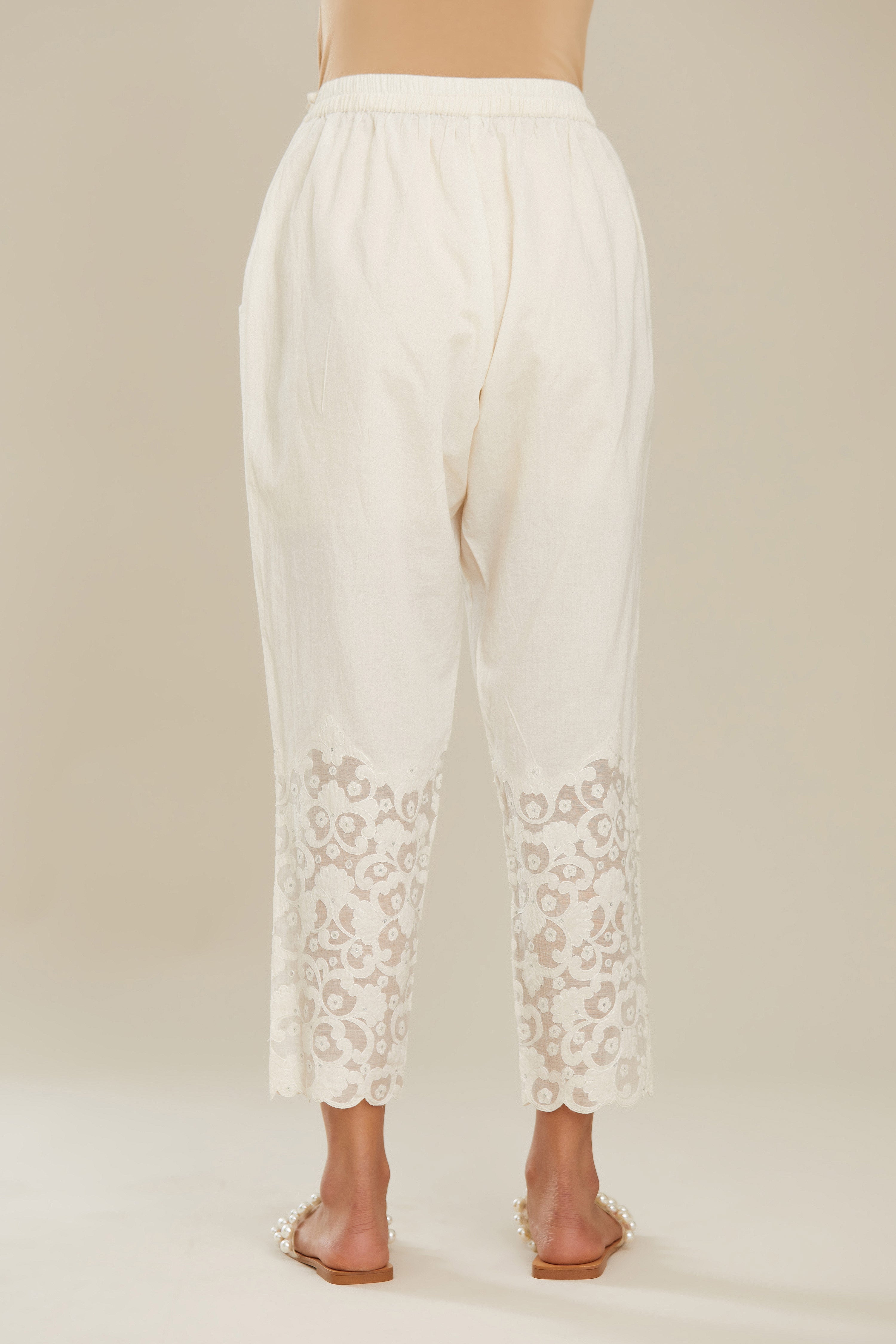 Off white cotton narrow pants with appliqué and hand attached sequins detailing. (Pants)