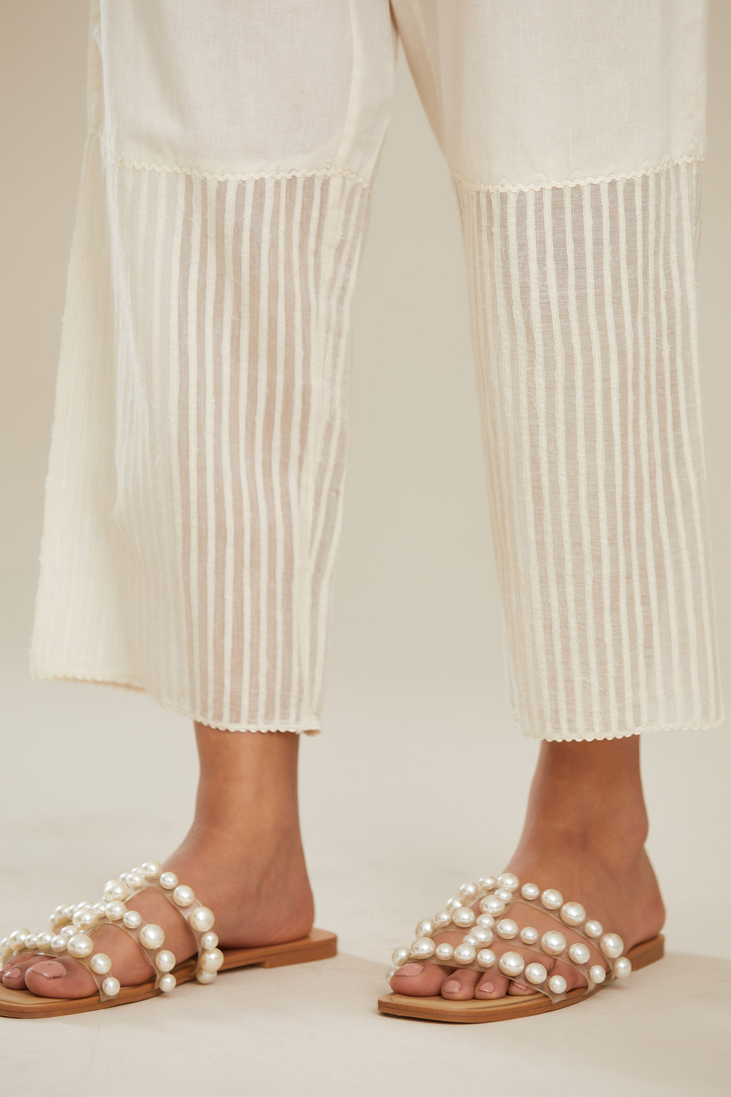 Off white cotton straight pants with striped appliqué till mid calf length. (Pants)