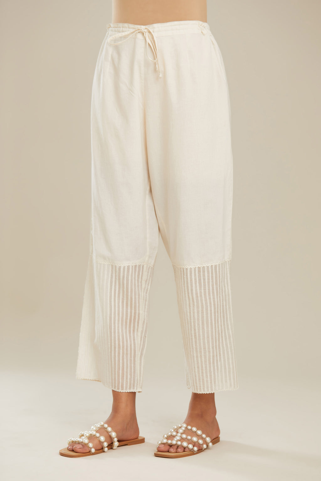Off white cotton straight pants with striped appliqué till mid calf length. (Pants)