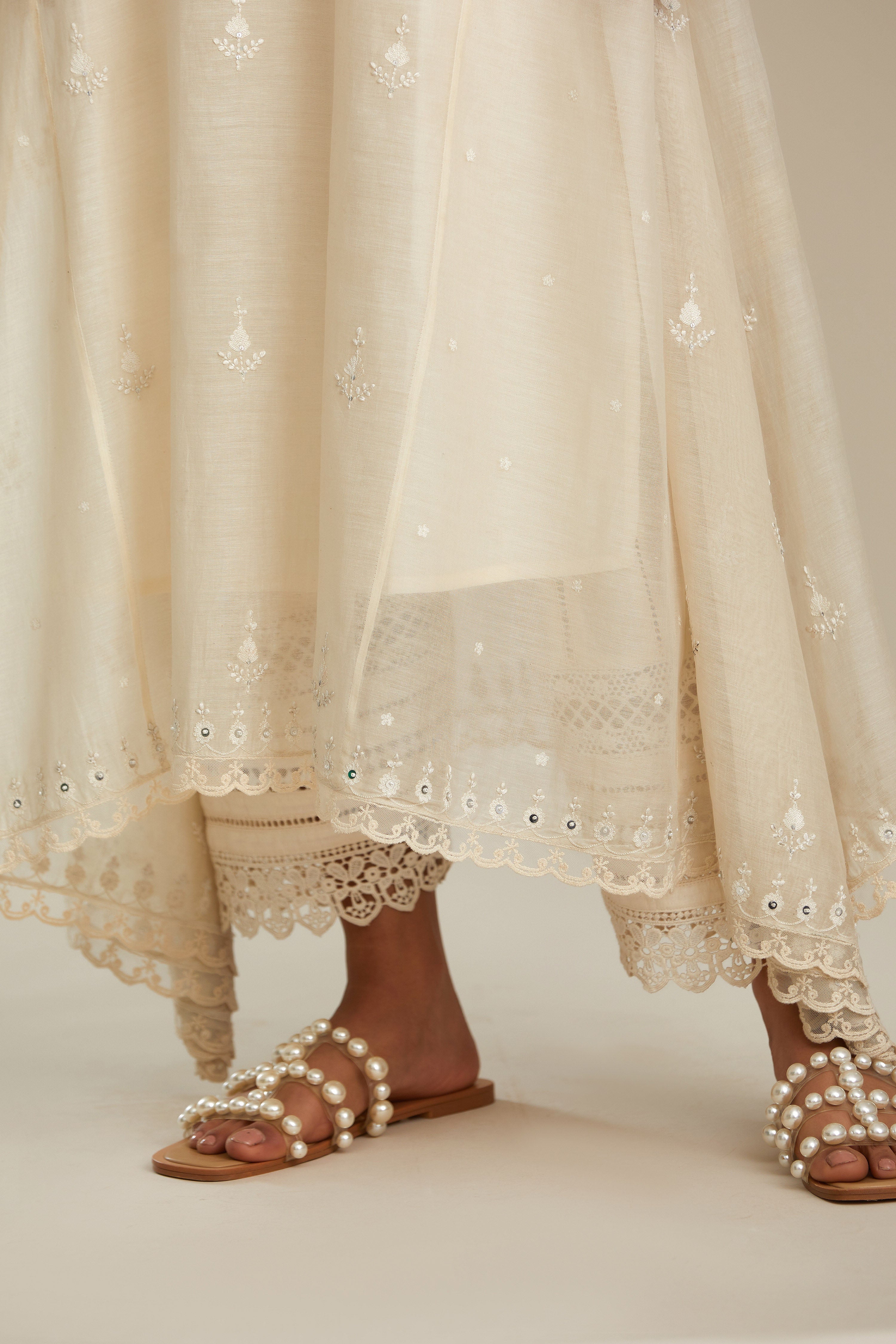 Off white cotton Chanderi kurta set with asymmetric hem, highlighted with sequins, beads and lace.