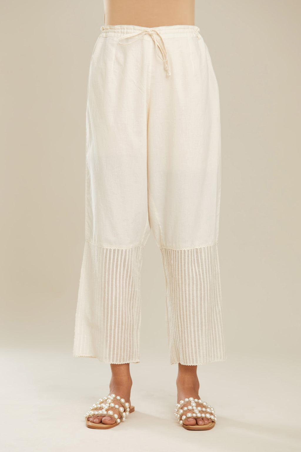 Off white cotton straight pants with striped appliqué till mid calf length. (Pants)