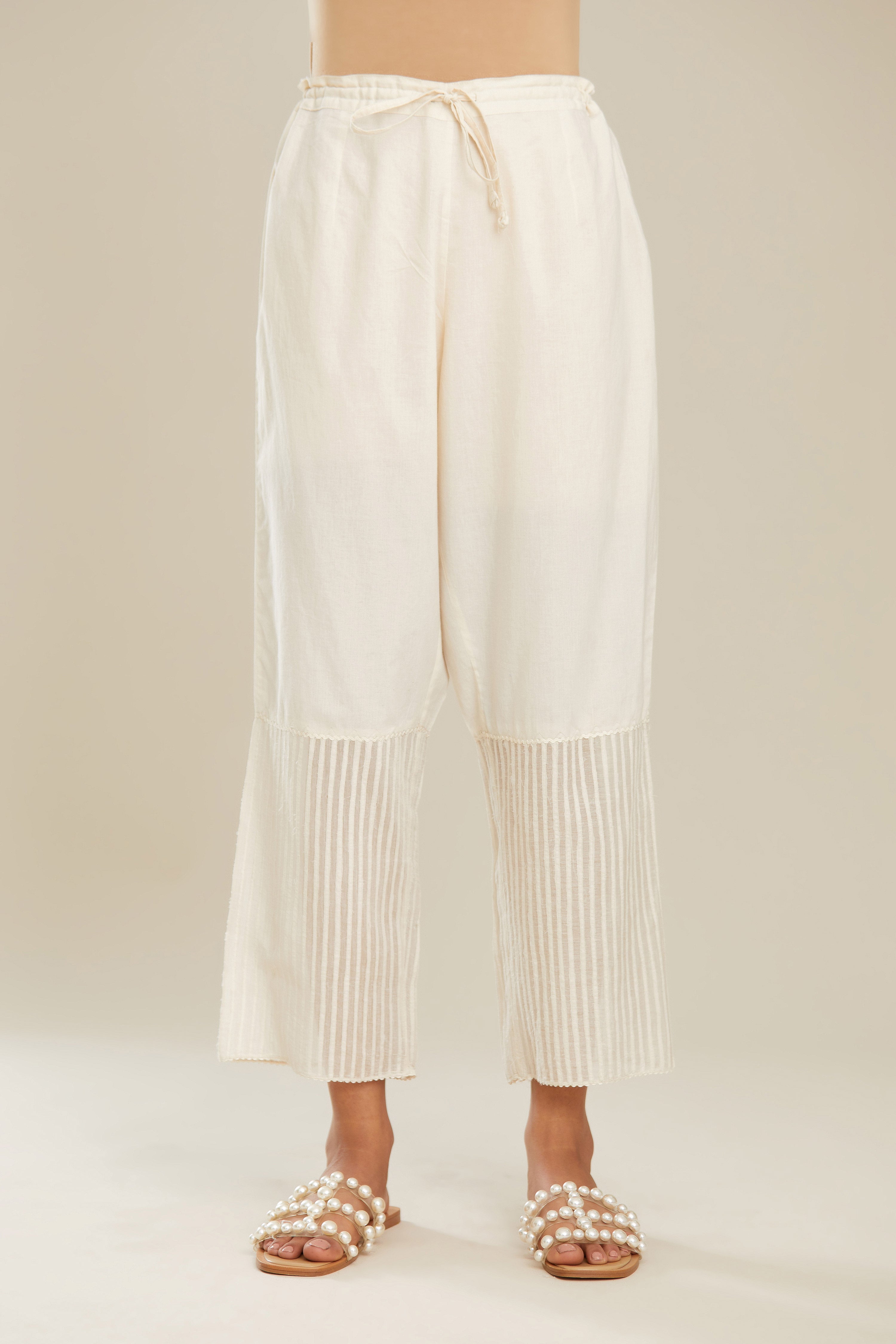 Off white cotton straight pants with striped appliqué till mid calf length. (Pants)