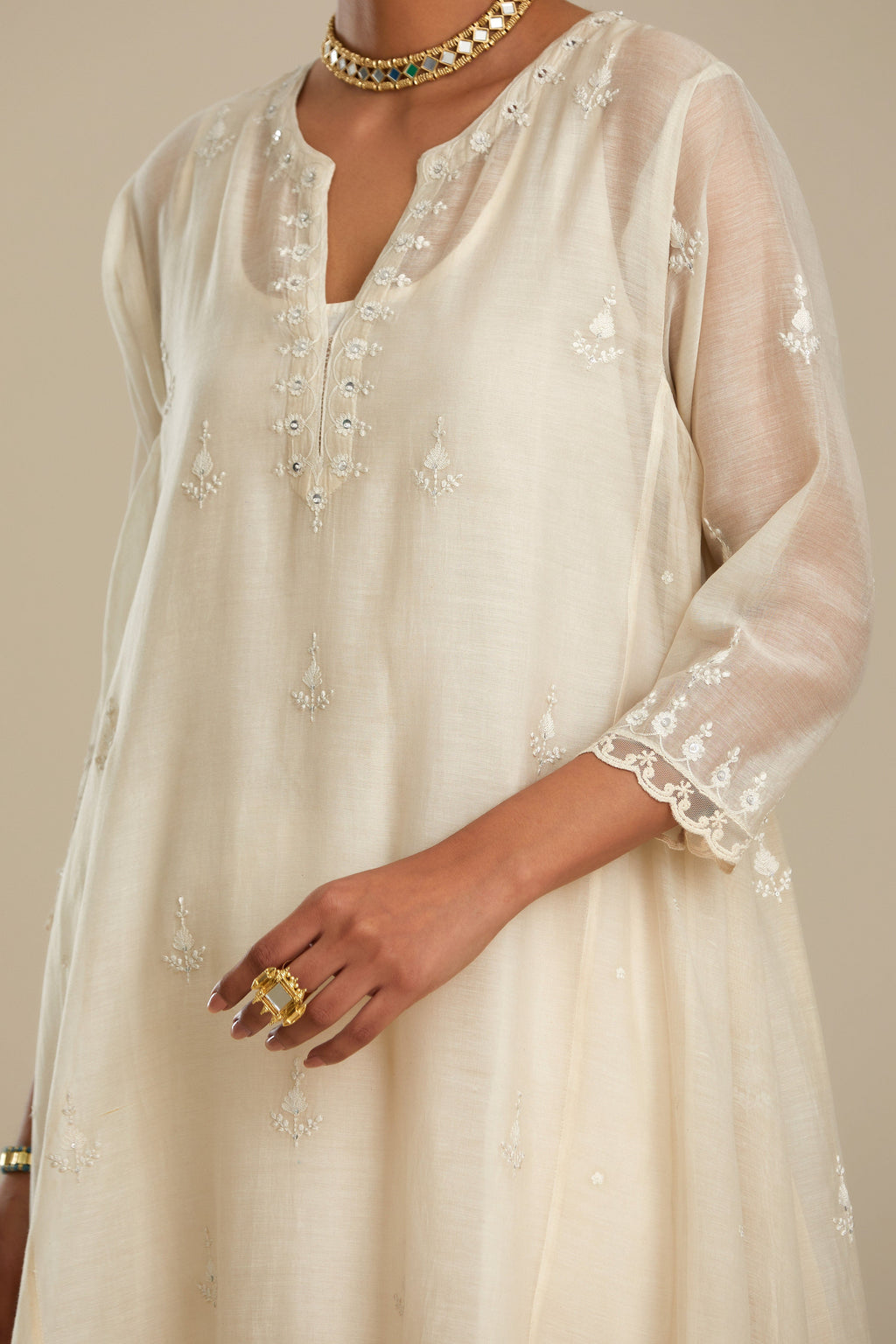 Off white cotton Chanderi kurta set with asymmetric hem, highlighted with sequins, beads and lace.