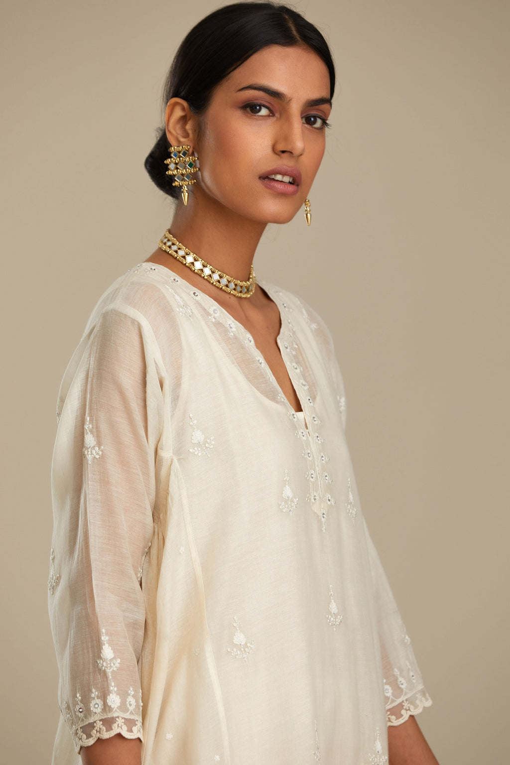 Off white cotton Chanderi kurta set with asymmetric hem, highlighted with sequins, beads and lace.