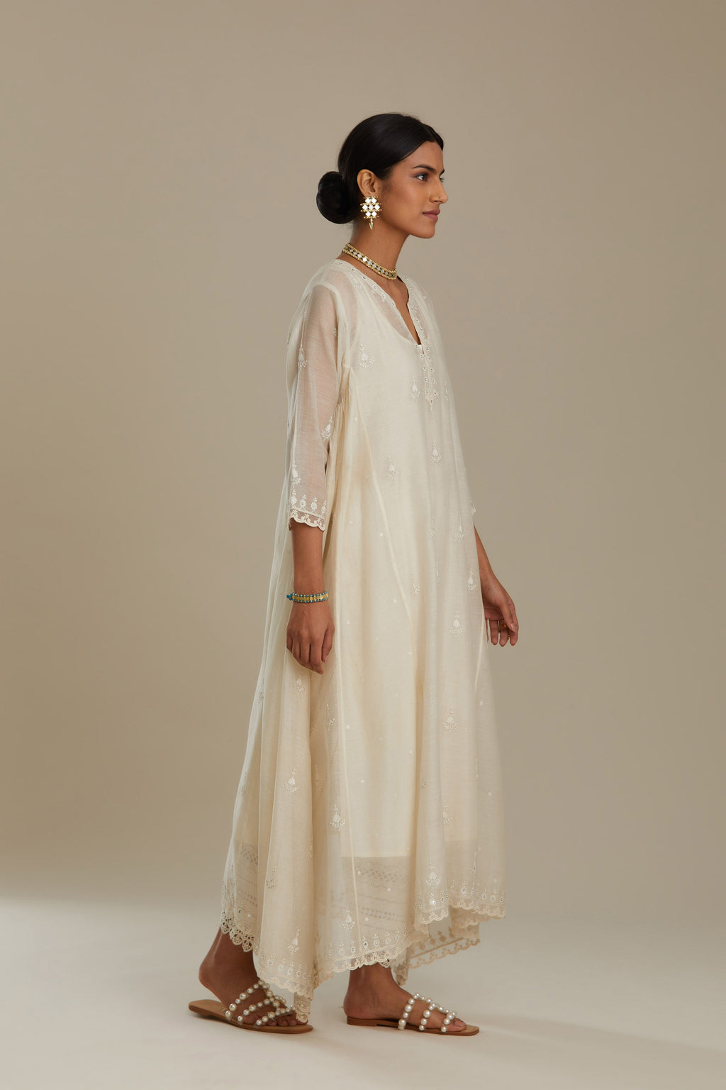 Off white cotton Chanderi kurta set with asymmetric hem, highlighted with sequins, beads and lace.