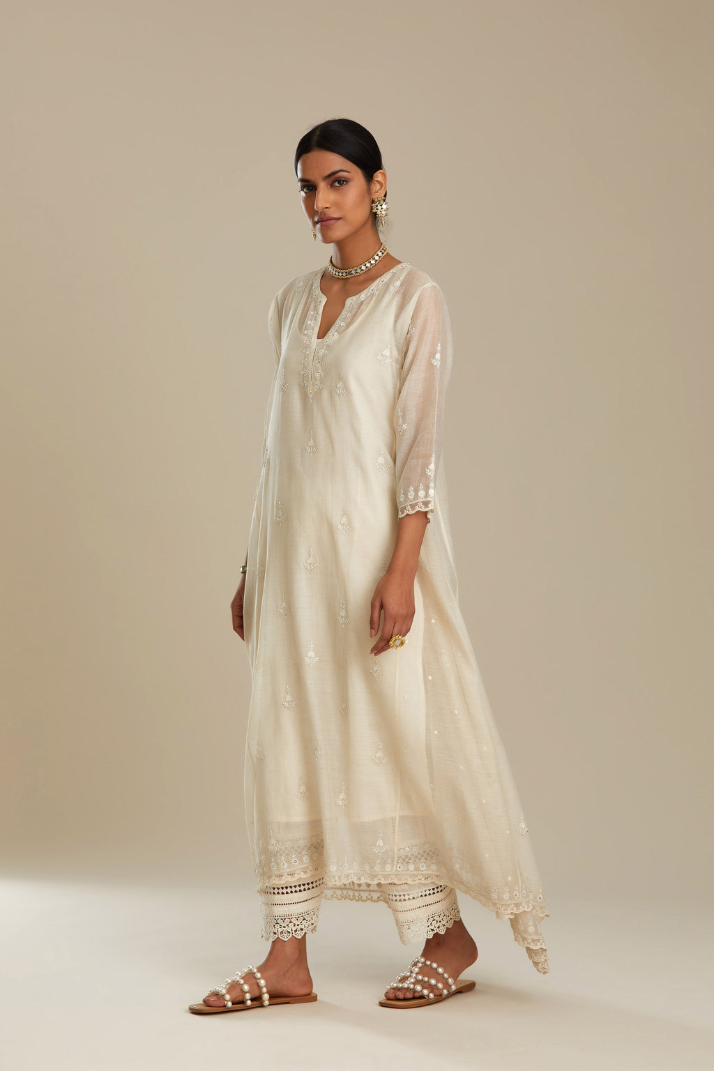 Off white cotton Chanderi kurta set with asymmetric hem, highlighted with sequins, beads and lace.
