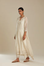 Off white cotton Chanderi kurta set with asymmetric hem, highlighted with sequins, beads and lace.