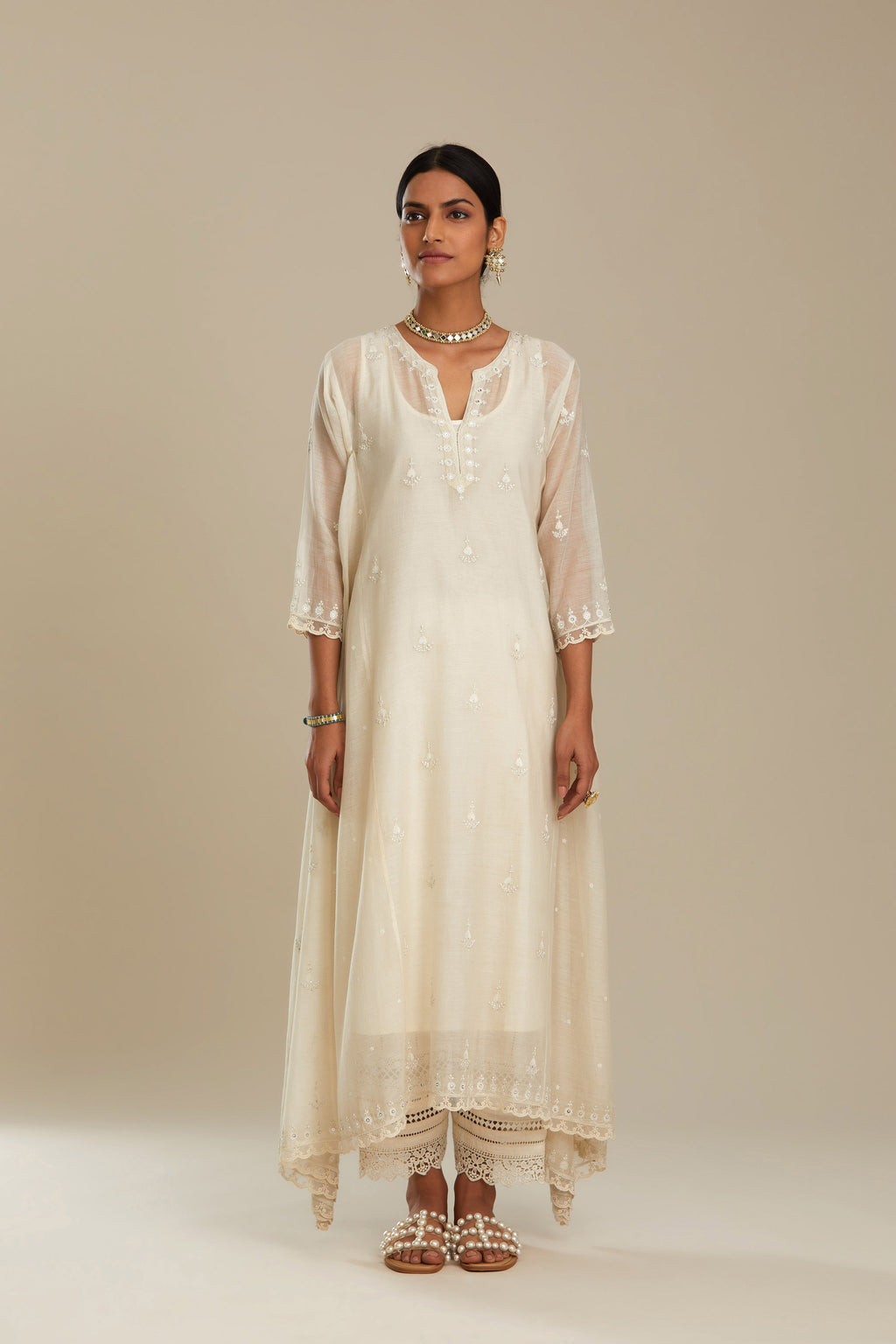 Off white cotton Chanderi kurta set with asymmetric hem, highlighted with sequins, beads and lace.