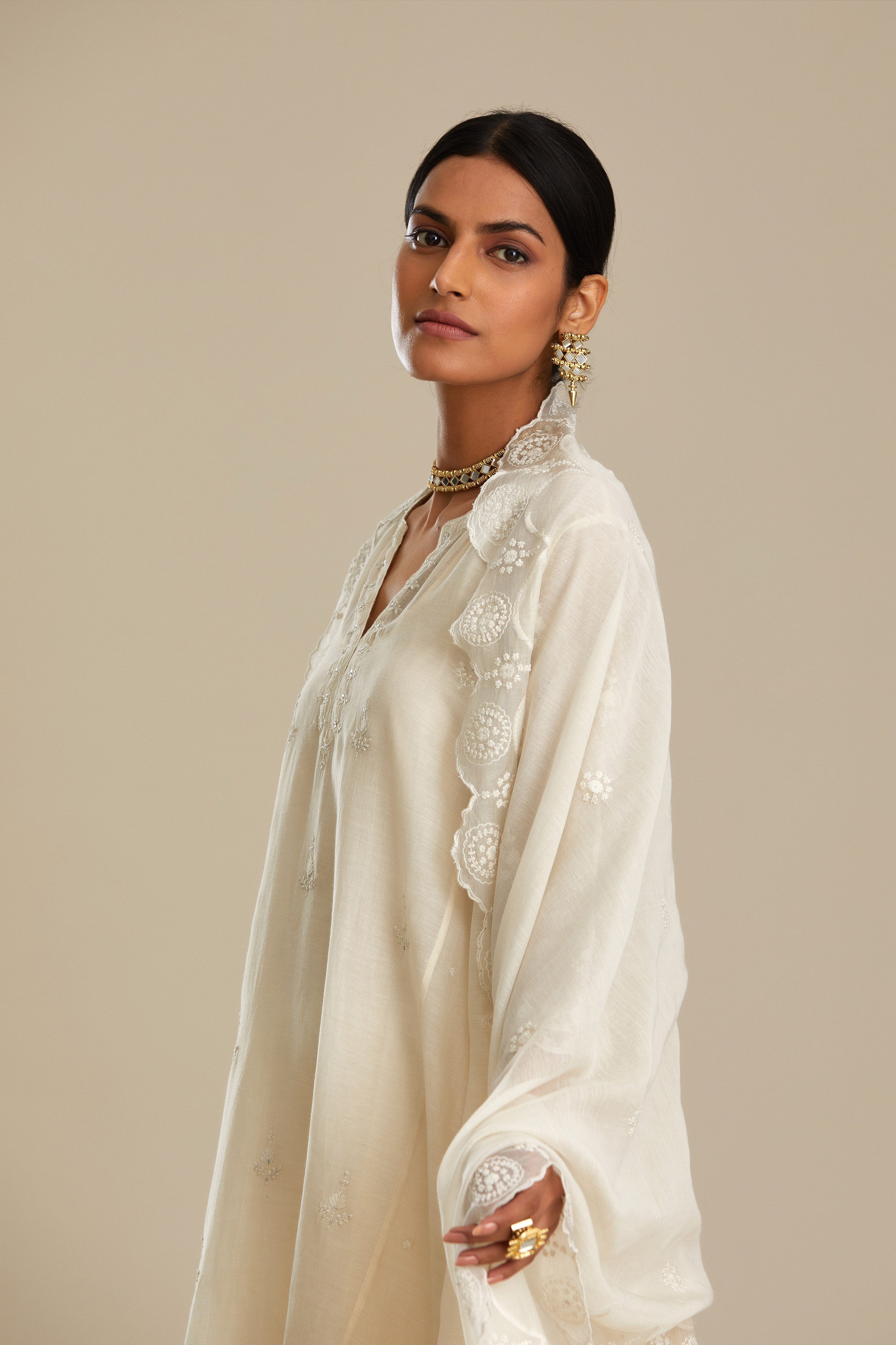 Off white cotton Chanderi kurta set with asymmetric hem, highlighted with sequins, beads and lace.