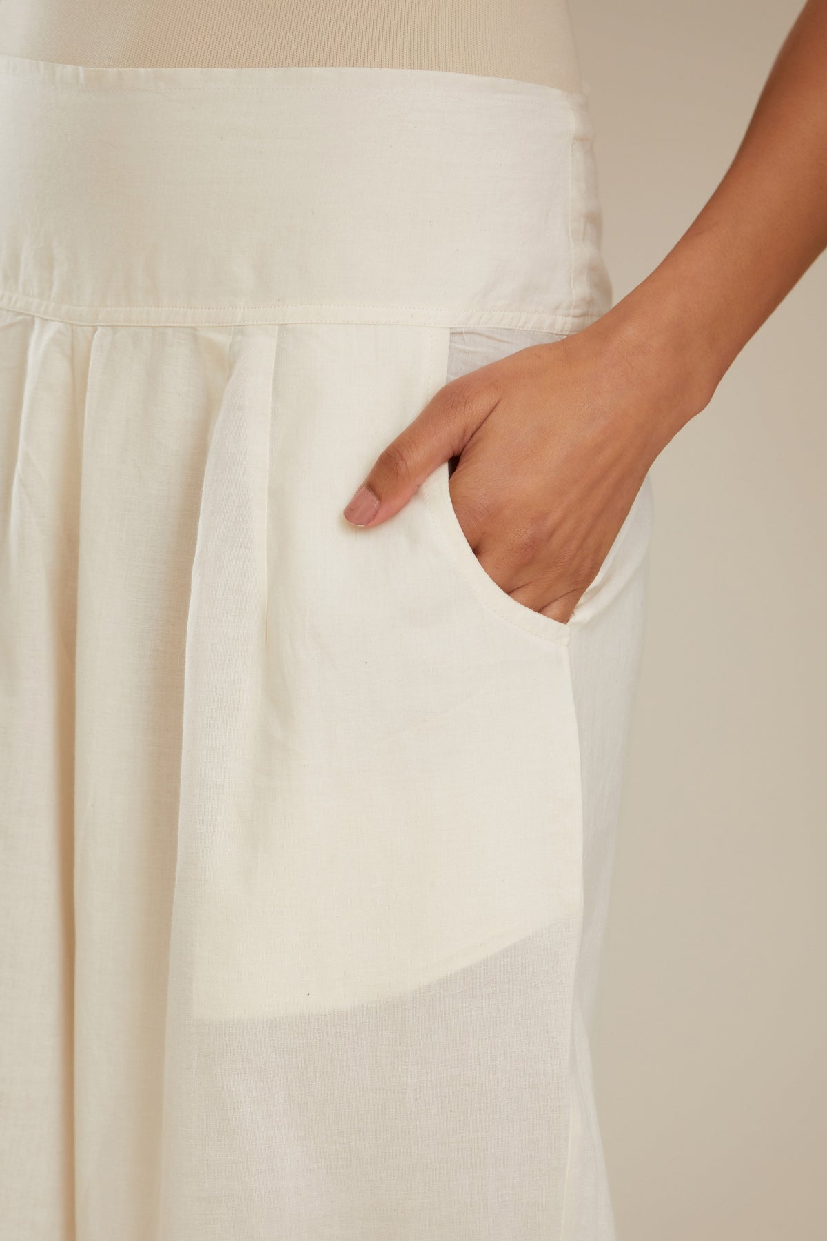 Off white cotton straight pants with appliqué detail at hem, highlighted with sequins. (Pants)