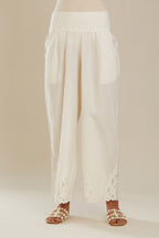 Off white cotton straight pants with appliqué detail at hem, highlighted with sequins. (Pants)