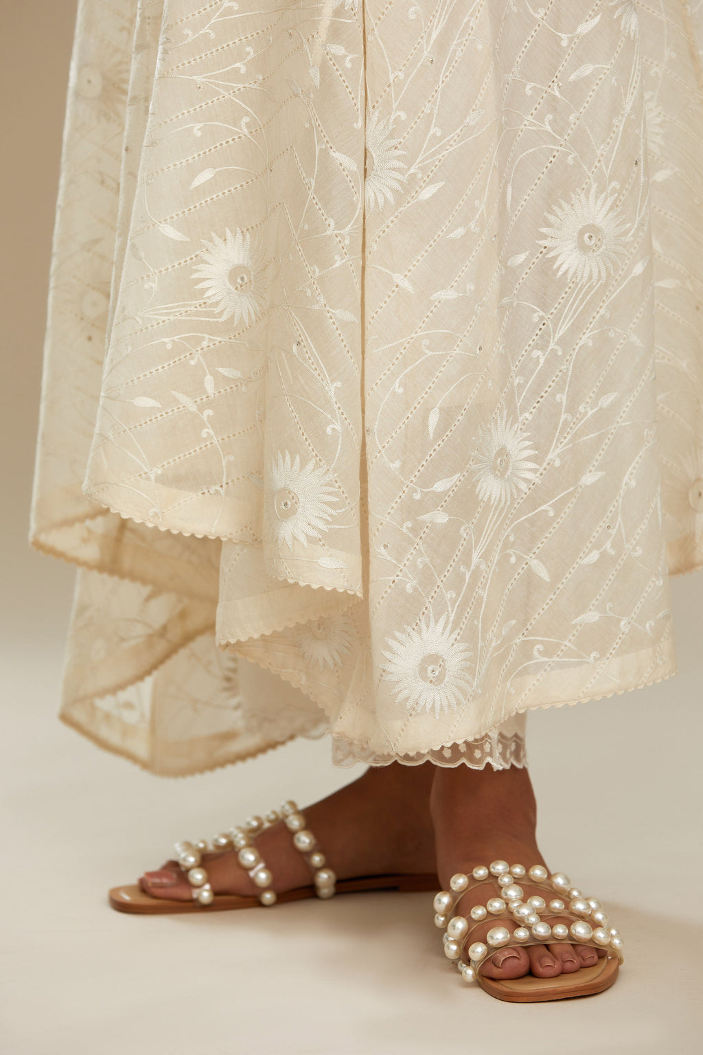 Off white cotton Chanderi kurta set with fagotting and an asymmetric hem, highlighted with silk thread floral jaal embroidery and sequins.
