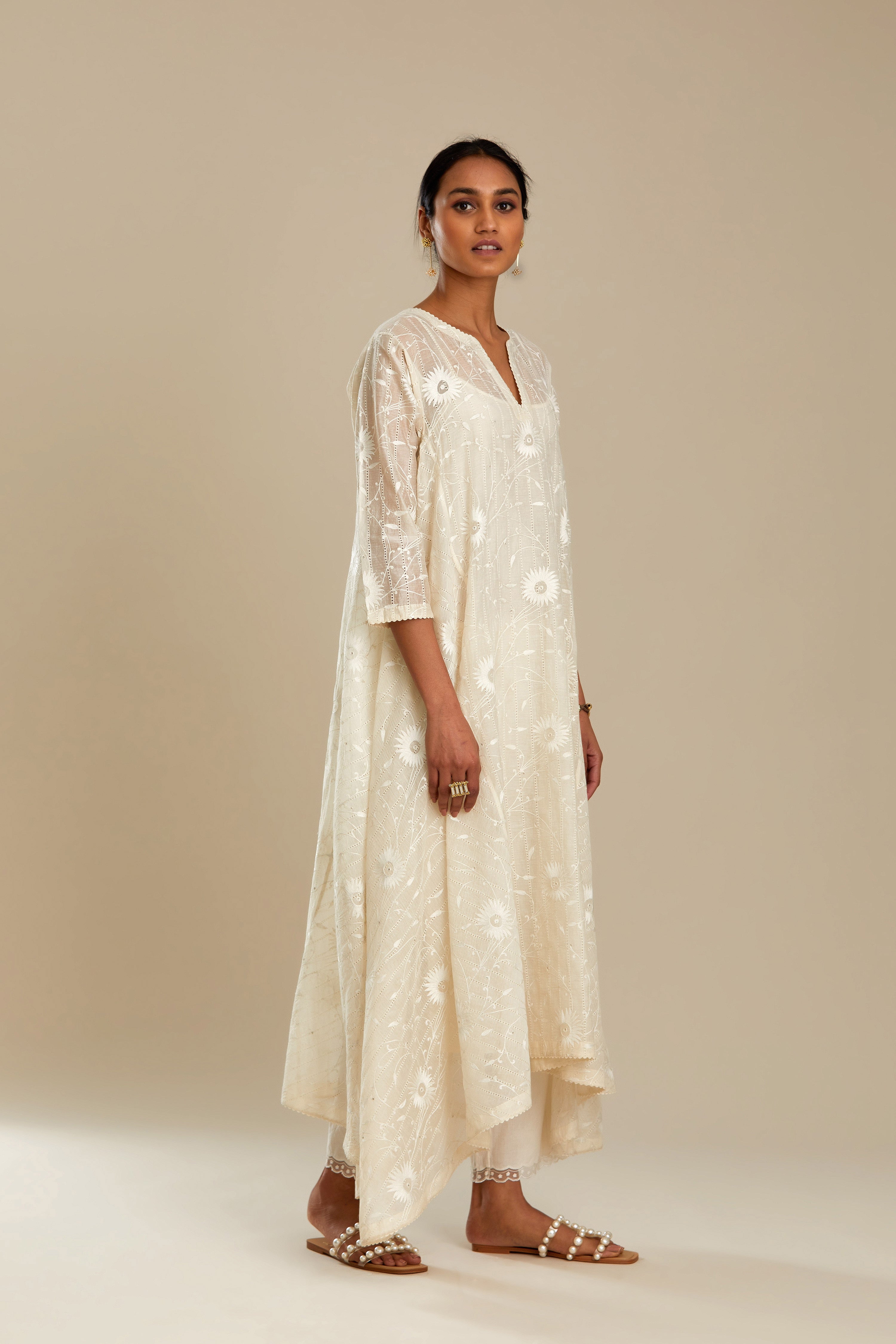 Off white cotton Chanderi kurta set with fagotting and an asymmetric hem, highlighted with silk thread floral jaal embroidery and sequins.