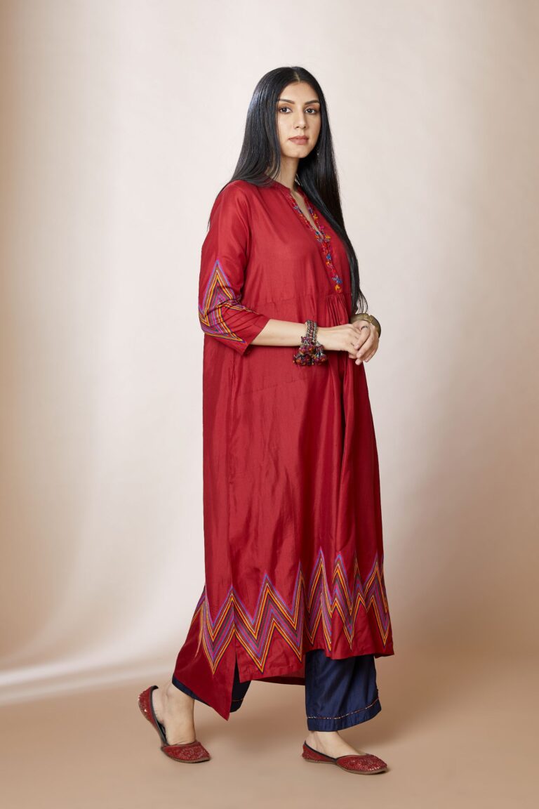 Maroon silk A-line kurta set with multi coloured chevron embroidery and overlapped neckline