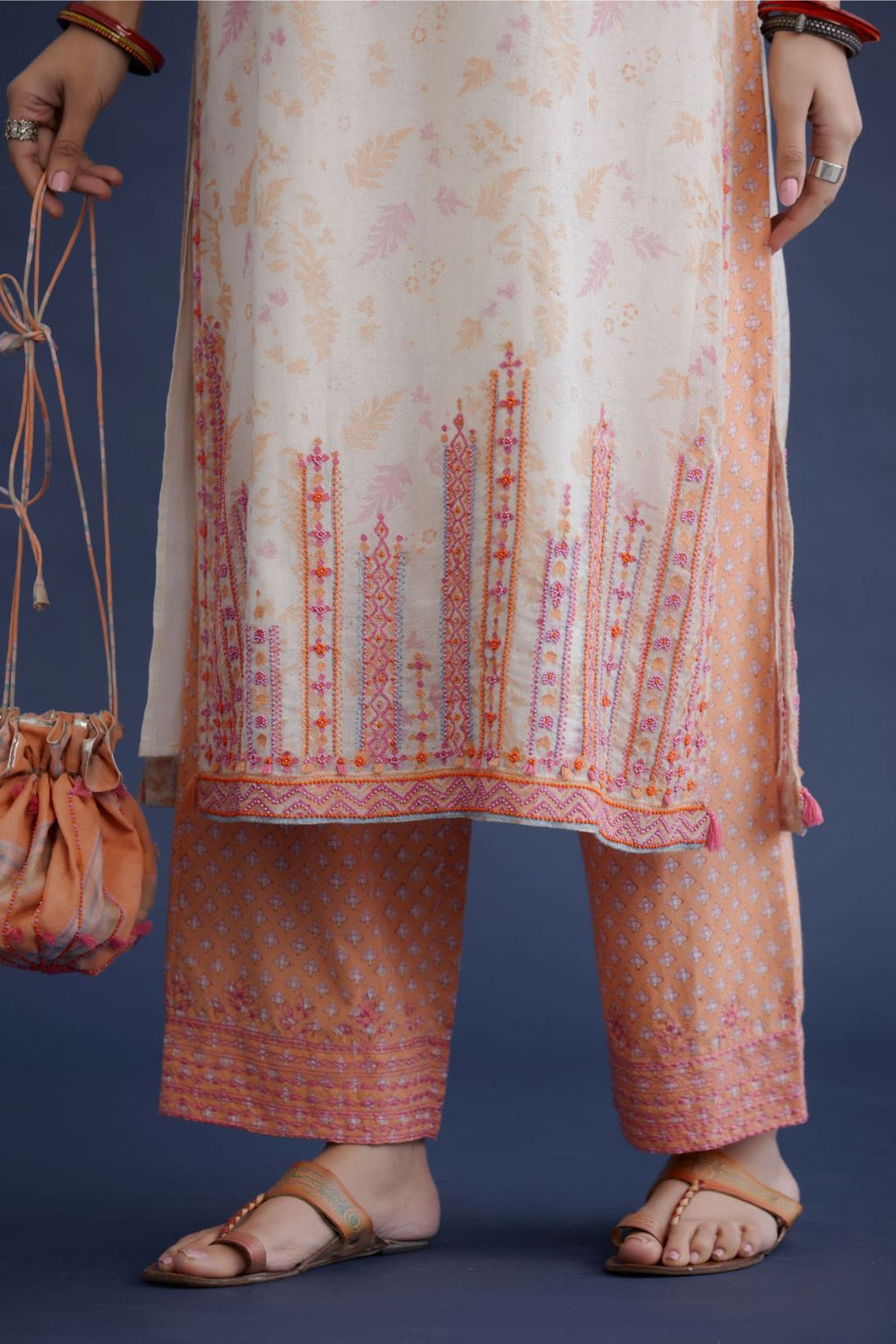 Off white hand block printed straight kurta set with pink and orange thread embroidery and delicate beaded hand work at neck, sleeve and hem