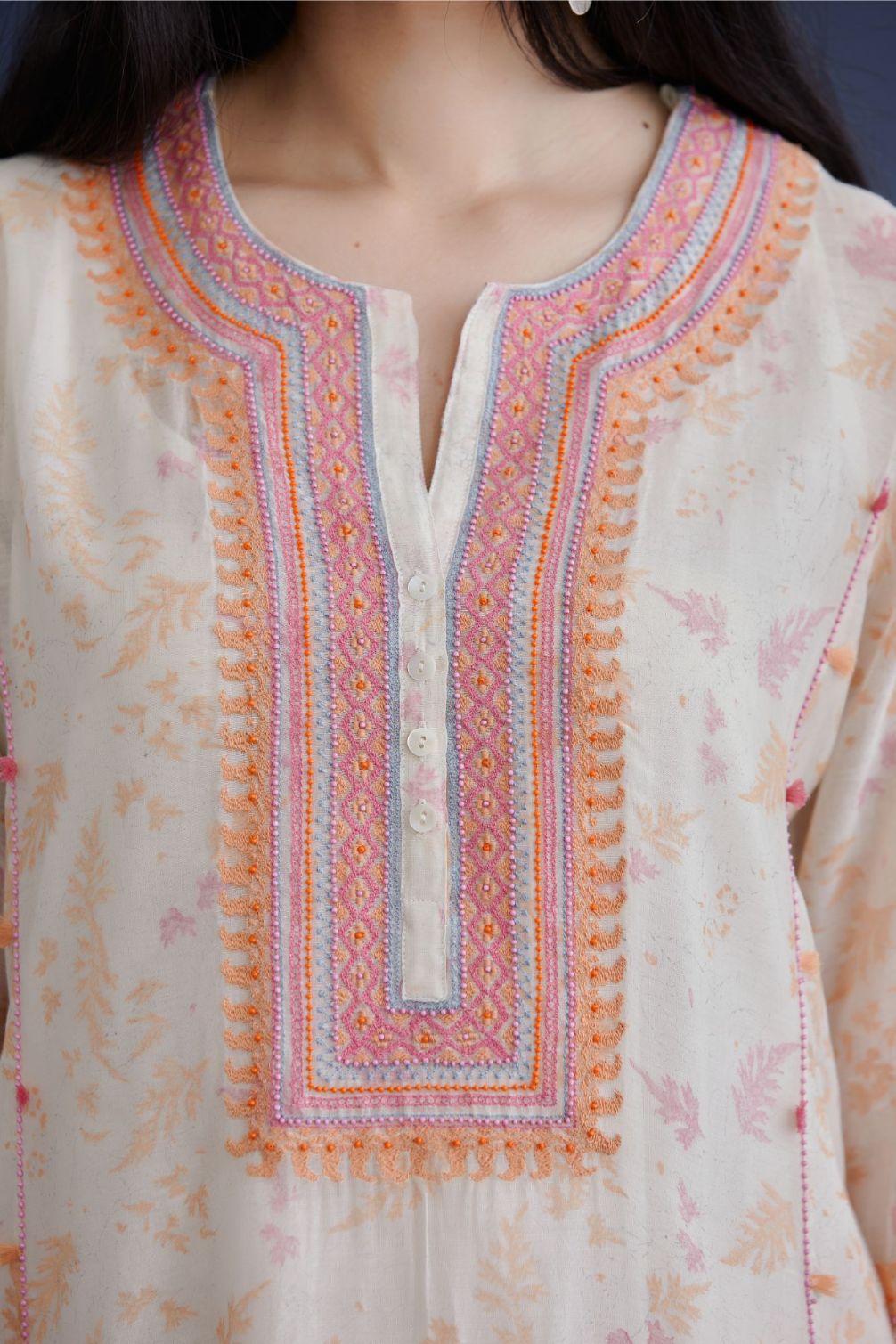 Off white straight kurta set with heavy embroidered button placket neckline and delicate bead and tassel embroidery at side panel joint seams