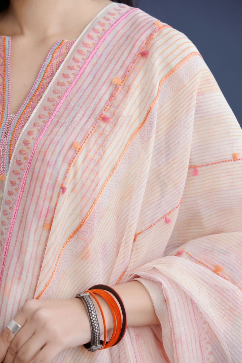 Off white cotton Chanderi dupatta with all over pink and orange hand block print, highlighted with bead and thread tassel embroidery