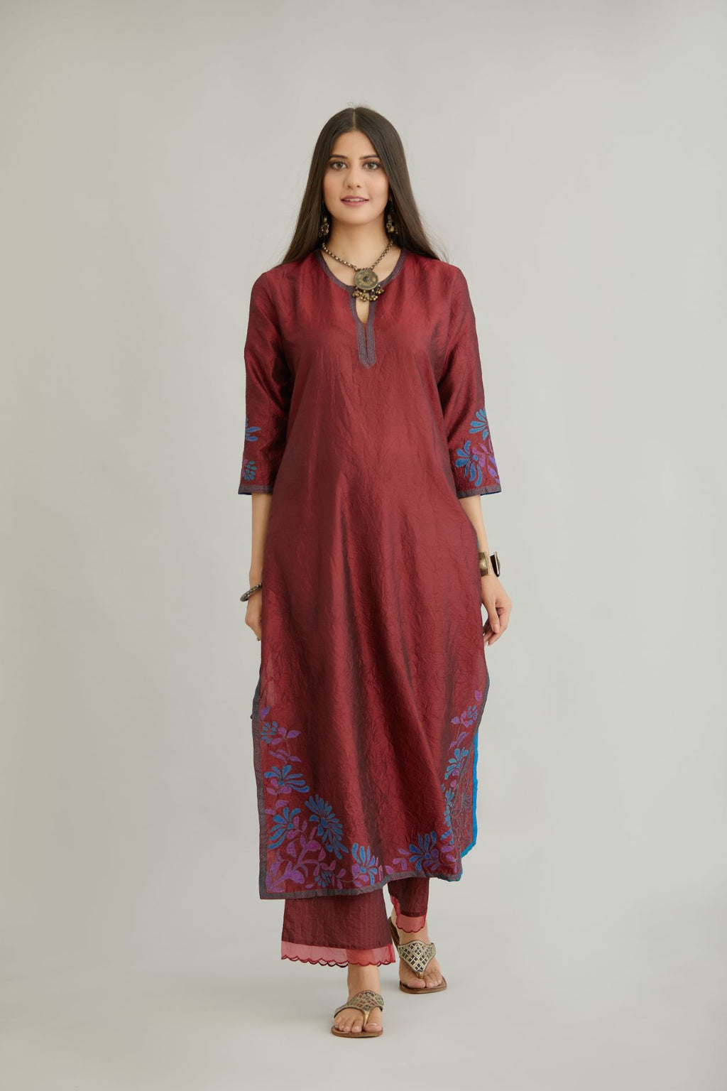 Maroon hand crushed silk kurta set with contrast silk fabric applique work at hem, side slits and sleeves with an embroidered neckline.
