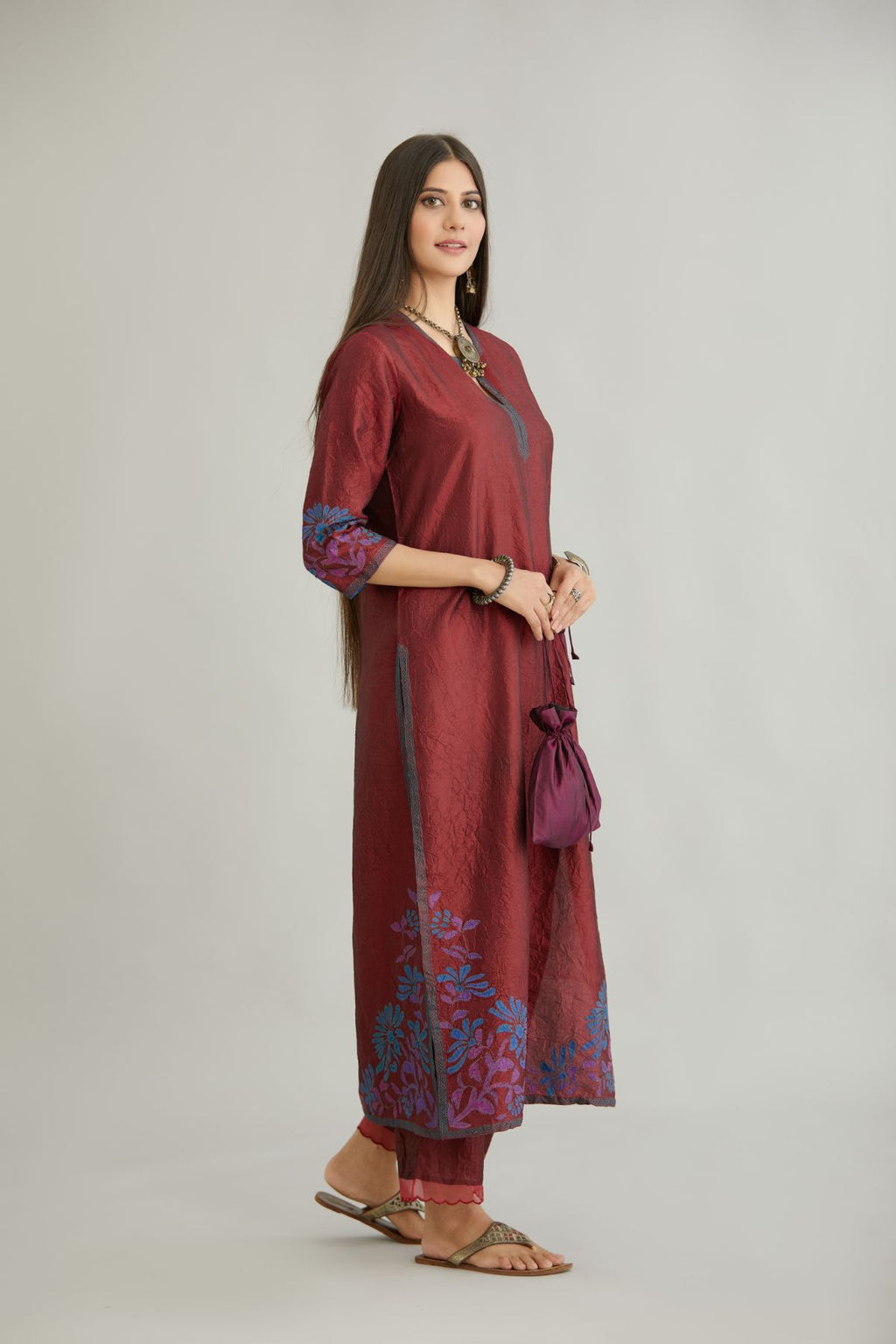 Maroon hand crushed silk kurta set with contrast silk fabric applique work at hem, side slits and sleeves with an embroidered neckline.