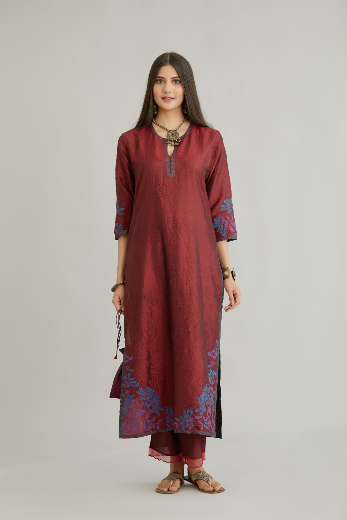 Maroon hand crushed silk kurta set with contrast silk fabric applique work at hem, side slits and sleeves with an embroidered neckline.