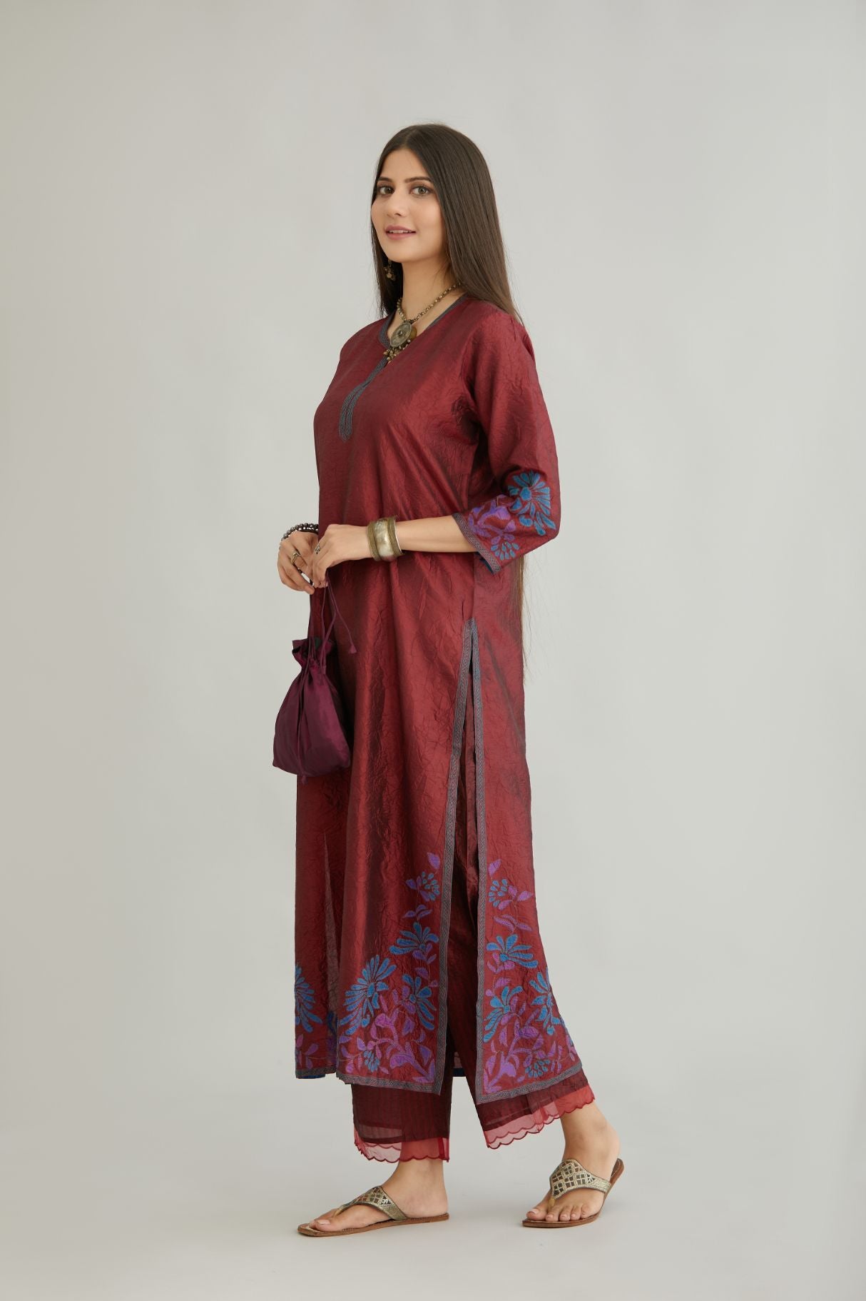Maroon hand crushed silk kurta set with contrast silk fabric applique work at hem, side slits and sleeves with an embroidered neckline.