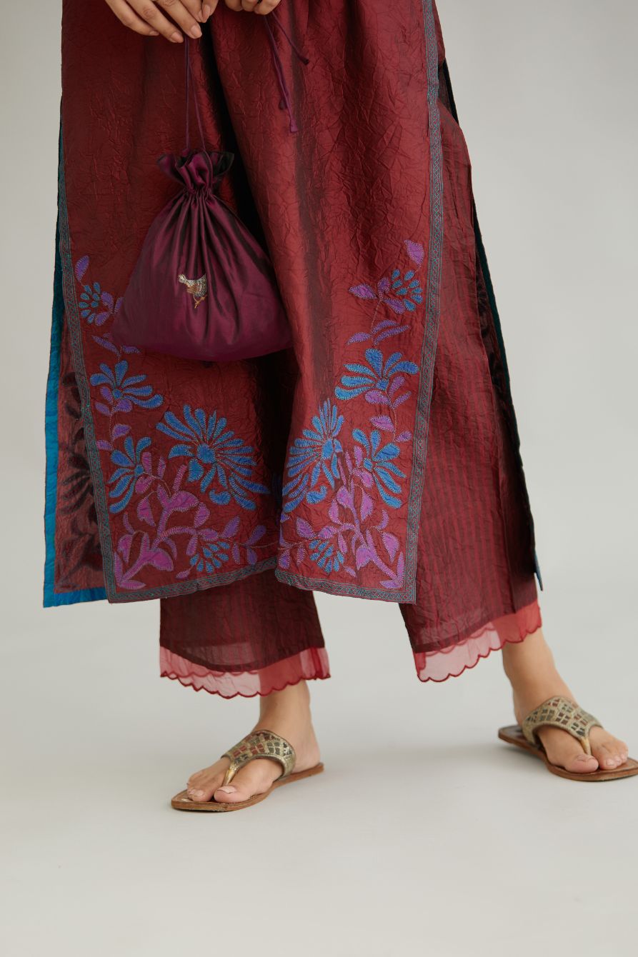 Maroon hand crushed silk kurta set with contrast silk fabric applique work at hem, side slits and sleeves with an embroidered neckline.