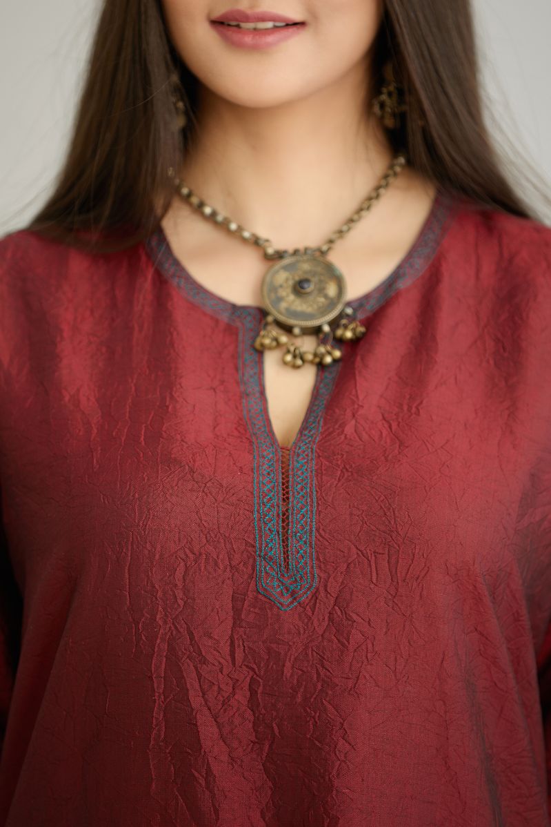 Maroon hand crushed silk kurta set with contrast silk fabric applique work at hem, side slits and sleeves with an embroidered neckline.